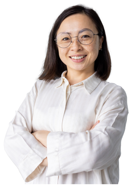 BDD-for-scrum-teams-Hero A person in a white blouse and glasses smiles and poses for the camera with arms crossed
